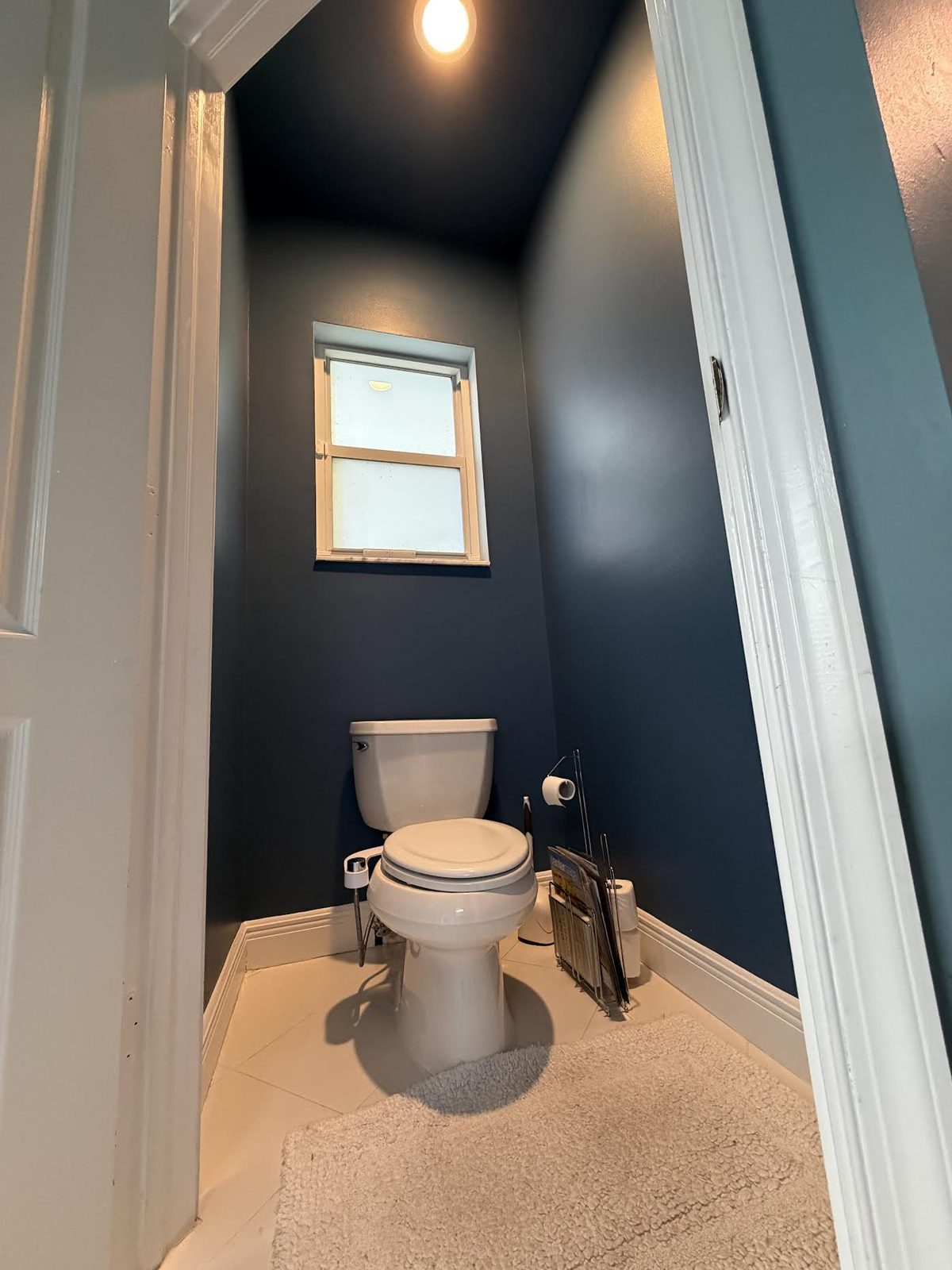 Powder room painted in a deep navy