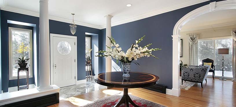 Interior painting — deep navy foyer with white columns and trim